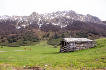 cabaña de piedra con la montaña de fondo