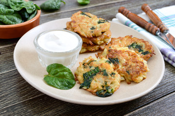 Pancakes with cabbage and spinach. Juicy vegetable cutlets on a plate with sour cream. Diet menu. Lenten dish.