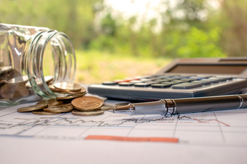 Pens and coins placed on financial reports or stock market graph analysis.