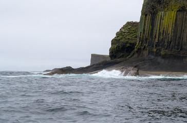 Staffa island seen from the ferry boat. It is a wild little island not far from Mull island in Scotland. Its rocks are hexagon shaped for the volcanic formation process. It's a protected natural space