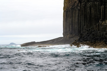 Staffa island seen from the ferry boat. It is a wild little island not far from Mull island in Scotland. Its rocks are hexagon shaped for the volcanic formation process. It's a protected natural space