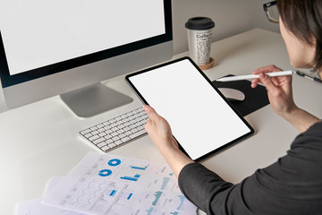 Mockup mobile tablet template with white screen used by a caucasian business woman 