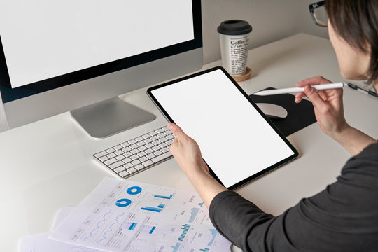 Mockup mobile tablet template with white screen used by a caucasian business woman 