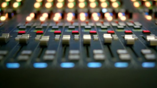 detail view on levers and buttons of mixing console in recording studio