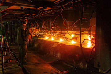 Workers at the metallurgical plant clean five steel feed channels in a continuous casting machine.
