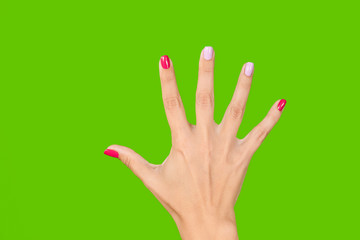 Closeup view photography of beautiful manicured in bright trendy colorful pink and purple colours nails. Woman raising one hand up isolated on green background.