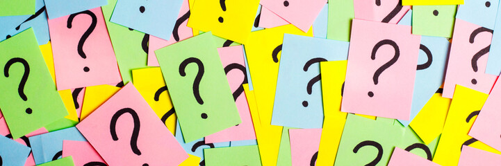 Too Many Questions. Pile of colorful paper notes with question marks. Closeup.