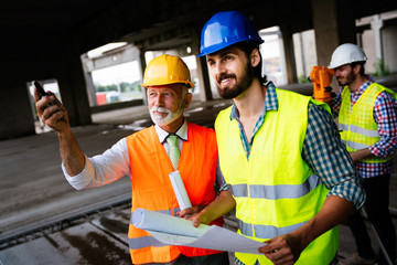 Team of construction engineers, architects working on building site