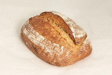 The grey loaf of rye bread, an assortment of bread and bakery products. Closeup on a light background