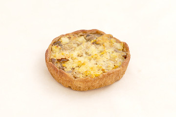 Round tartlet filling the kiln with cheese. Range of bakery and bread products. Closeup on a light background