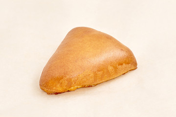 Homemade pie triangular shaped pastry with filling. Closeup on a light background