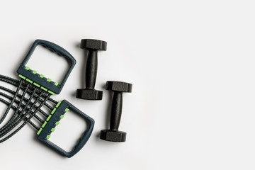 Expander and two dumbbells isolated on a white background.