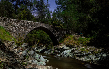 Fototapeta na wymiar Ancient stone Venetian bridge in the Troodos mountains on the island of Cyprus.