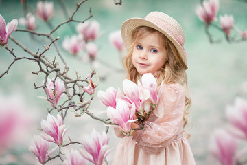 Fototapeta premium little girl in the garden Magnolia