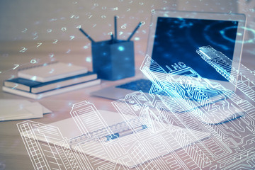 Desktop computer background in office and big town buildings hologram drawing. Double exposure. Smart city concept.