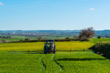 Fototapeta premium Tractor spraying crops
