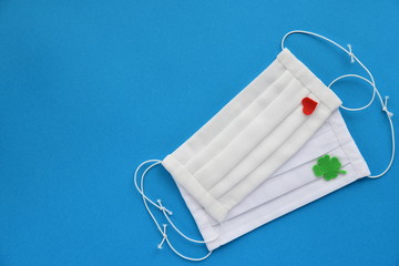 手作りガーゼマスク　四葉のクローバーと赤いハートの飾り付き　背景青