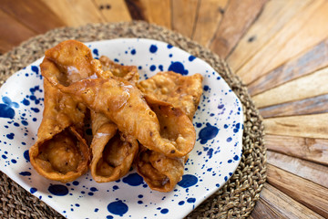  Top view of typical sweets of Spanish gastronomy on rustic wooden table and polka dot plate (Pestiños)
