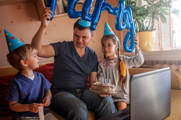 Happy father with two sibling celebrating birthday via internet in quarantine time, self-isolation