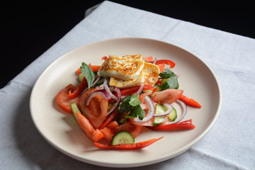 Grilled Halloumi Cheese salad with tomatoes, cucumbers, red pepper, red onion. Healthy vegeterian food. Keto diet.