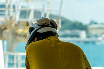 An offshore supervisor overlooking main deck of a construction work barge from the bridge