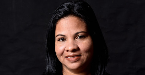 portrait of a woman on black background, looking at camera
