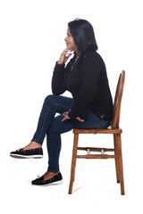 portrait of a woman sitting on a chair in white background, legs crossed and hand on chin