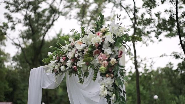 wedding, white, decorative arch on a background of green plants