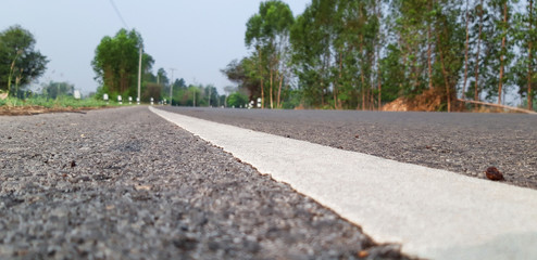 The surface of the paved road has a dividing line for traffic lanes.