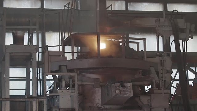 The molten metal is poured. Modern induction furnace in Pouring Hot Liquid Metal From Furnace Metallurgical Plant. Steel industry