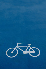 Fototapeta premium road sign of a bicycle painted on the ground on blue background