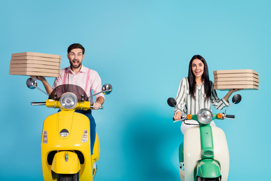 Photo of funny excited lady guy drive two vintage moped carry paper pizza boxes courier profession fast junk fastfood delivery formalwear outfit isolated blue color background