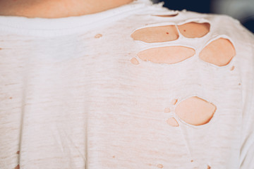 A holey old white T-shirt. View from the back.