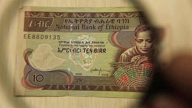 View a Ten Ethiopian Birr bill lying on a table with a magnifying glass. concept of business and finance.