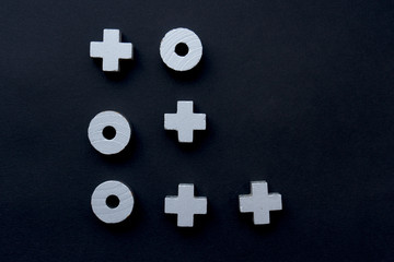 A noughts and crosses game lies on a black background