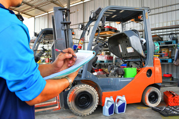 The mechanic is checking the quality and Maintenance Forklift,Energy fuel concept.