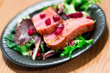 Raw tuna slices with frisee and pomegranate grains