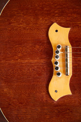 a wooden guitar is lying on a wooden table. The guitar strings are arranged horizontally