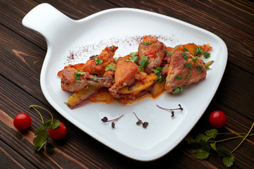 Fototapeta premium Chicken with potatoes, tomatoes, sweet onions and cilantro, chihirtma chicken