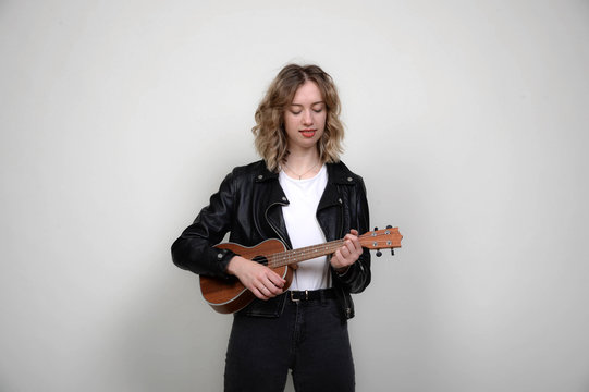 frau cool modern blonde locken jung spielt gitarre gitare