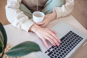 work from home. Distance education, learning. Woman's hands typing on laptop at home close up. Selective focus.