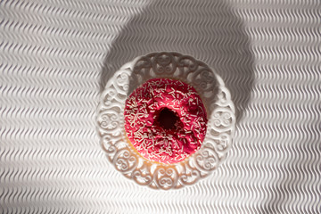 Pink Doughnut in a Vintage White Plate on a White Bakground