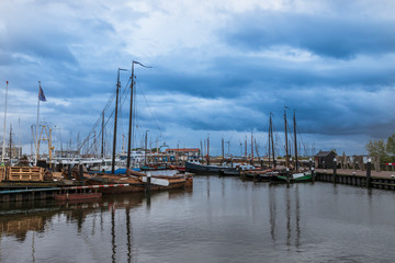 Fototapeta na wymiar Boat in harbor in Urk city in Holland. Docks where ships are repaired. The background is a blue sky with clouds.