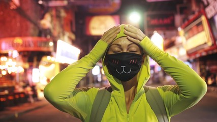 Woman close up look caucasian at Pattaya Walking Street with wearing protective medical mask....