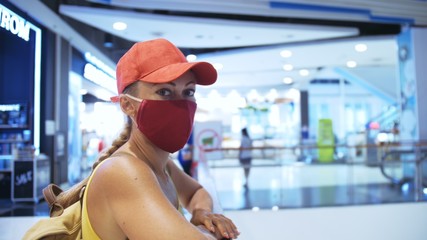 Woman travel caucasian visitor at a supermarket with wearing protective medical mask. Girl tourist...