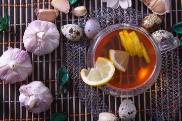 Healthy food, lemon tea, garlic, quail eggs photo for text advertising