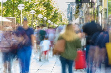 Blurred people walking on busy city sidewalk