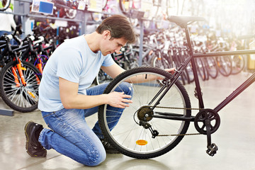 Obraz premium Man checks bike before buying in shop