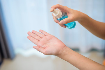 woman is cleaning her hands with alcohol spray