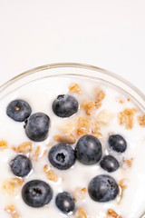 Healthy dessert with yogurt, muesli and blueberries on white background, isolated macro shot